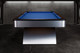 Wide profile of the Poshy Rainbow pool table by Doc & Holliday, highlighting brushed metallic rainbow base, Euro Blue felt, and sleek matte black rails on a concrete floor. Wide profile of the Poshy Rainbow pool table by Doc & Holliday, highlighting brushed metallic rainbow base, Euro Blue felt, and sleek matte black rails on a concrete floor.